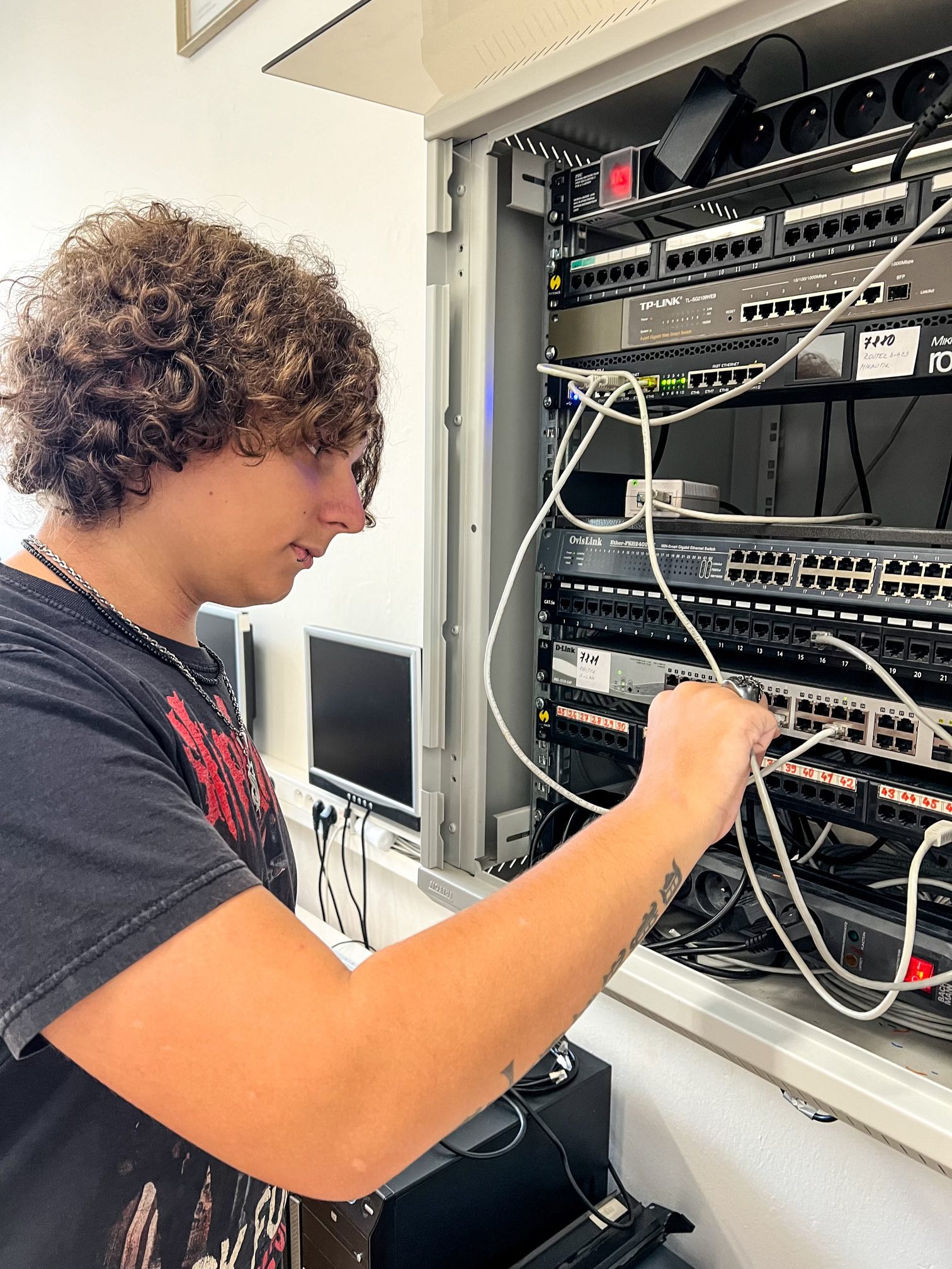 Žák v laboratoři zapojuje switch.